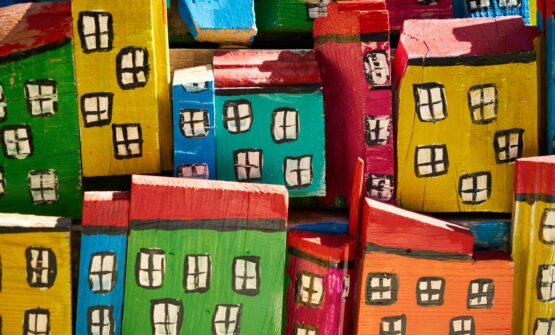 Von Kindern gebastelte, bunte Holzhäuser füllen den ganzen Bildausschnitt.